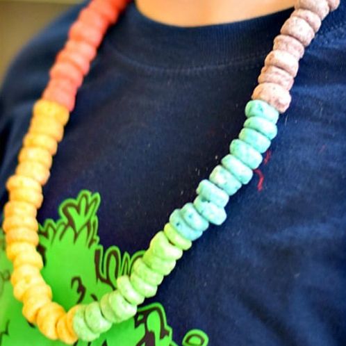 a child wears a necklace made of fruit loops, with the color changing every 10 pieces, to celebrate 100 days of school