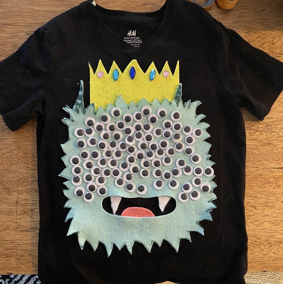 a shirt featuring a monster with 100 googly eyes celebrates the 100th day of school