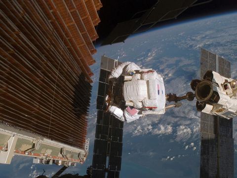 Astronaut Robert Curbeam werkt aan een van de grote zonnepaneelvleugels aan bakboordzijde van de P6ligger van het International Space Station ISS Aan het ISS worden voortdurend modules aangebouwd en reparaties uitgevoerd Wanneer het ruimtestation eenmaal is voltooid zal het groter zijn dan een woning van vijf kamers