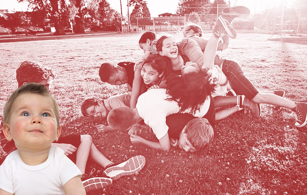 A bunch of children playing and laying on eachother in a pile 