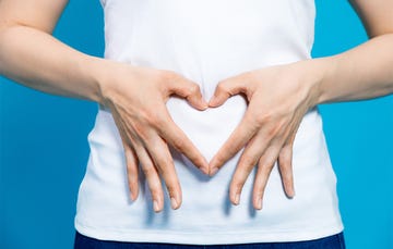 woman with hands on stomach heart shape