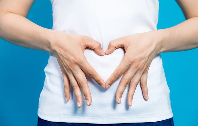 woman with hands on stomach heart shape