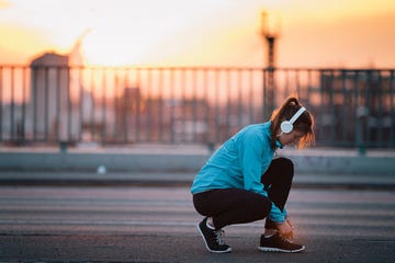 Woman stopping to tie shoes mid-run