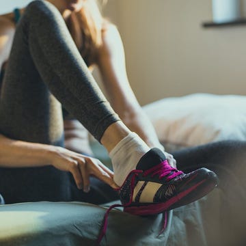 Woman putting on her running shoes Woman putting on her running shoes