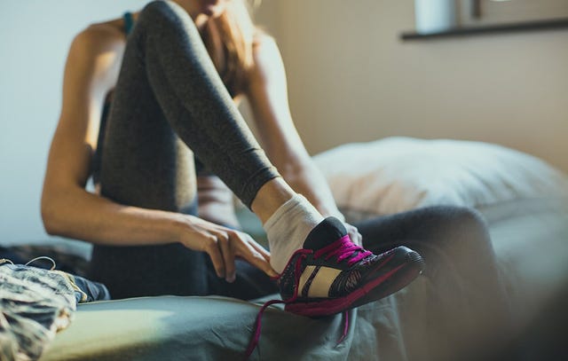 Woman putting on her running shoes