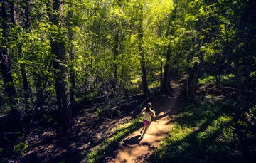 woman running through a trail