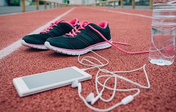 running shoes, an iPhone, and a water bottle on a track