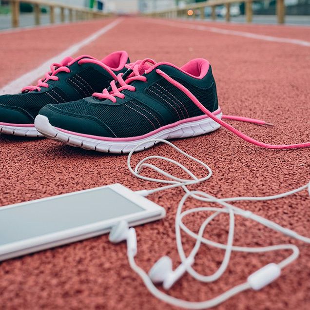 running shoes, an iPhone, and a water bottle on a track
