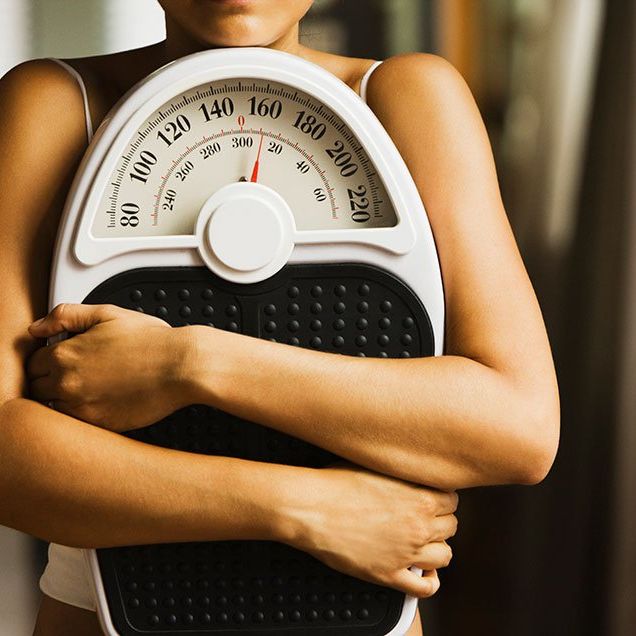 Woman clutching a weight scale
