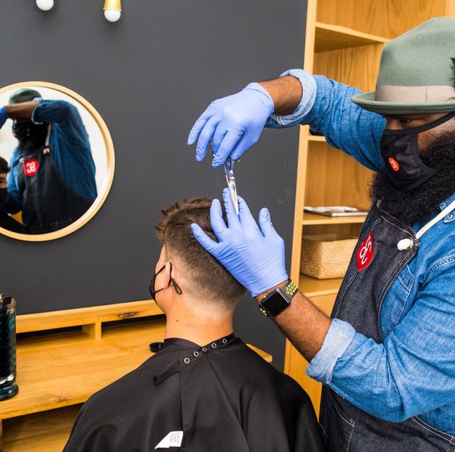 shortcut barber giving an in home haircut while wearing a mask during the coronavirus epidemic