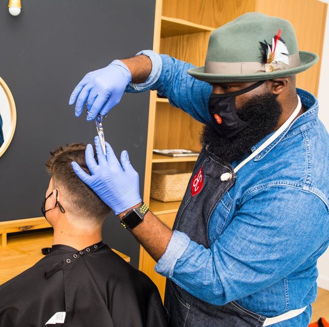 shortcut barber giving an in home haircut while wearing a mask during the coronavirus epidemic