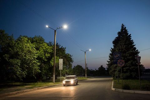Een auto rijdt door de hoofdstraat van Sjtsjastja Loehansk