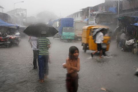 Een regenstorm overspoelt de straten van Dharavi in India in 2006
