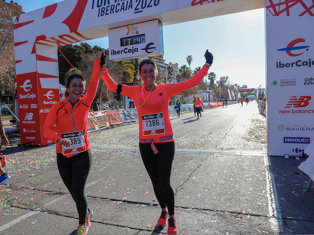 dos corredoras levantan los brazos triunfantes tras cruzar la meta del 10k valencia ibercaja