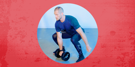 person performing a deadlift with dumbbells in a gym setting