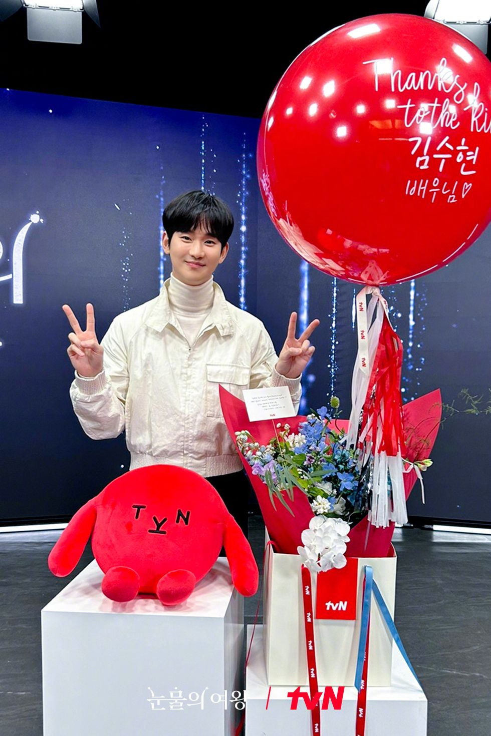 a person standing behind a podium with a red balloon and a red heart