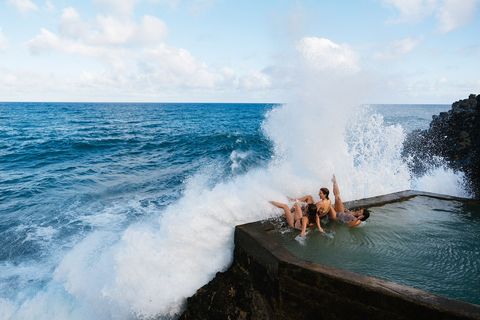 HONOLULU HAWA  In een zwembad aan zee bij Honolulu trotseren drie vrouwen de branding Oahu is het op twee na grootste  en meest bezochte  eiland van de Hawaarchipel De temperatuur van het zeewater schommelt hier het hele jaar door rond de 255 graden