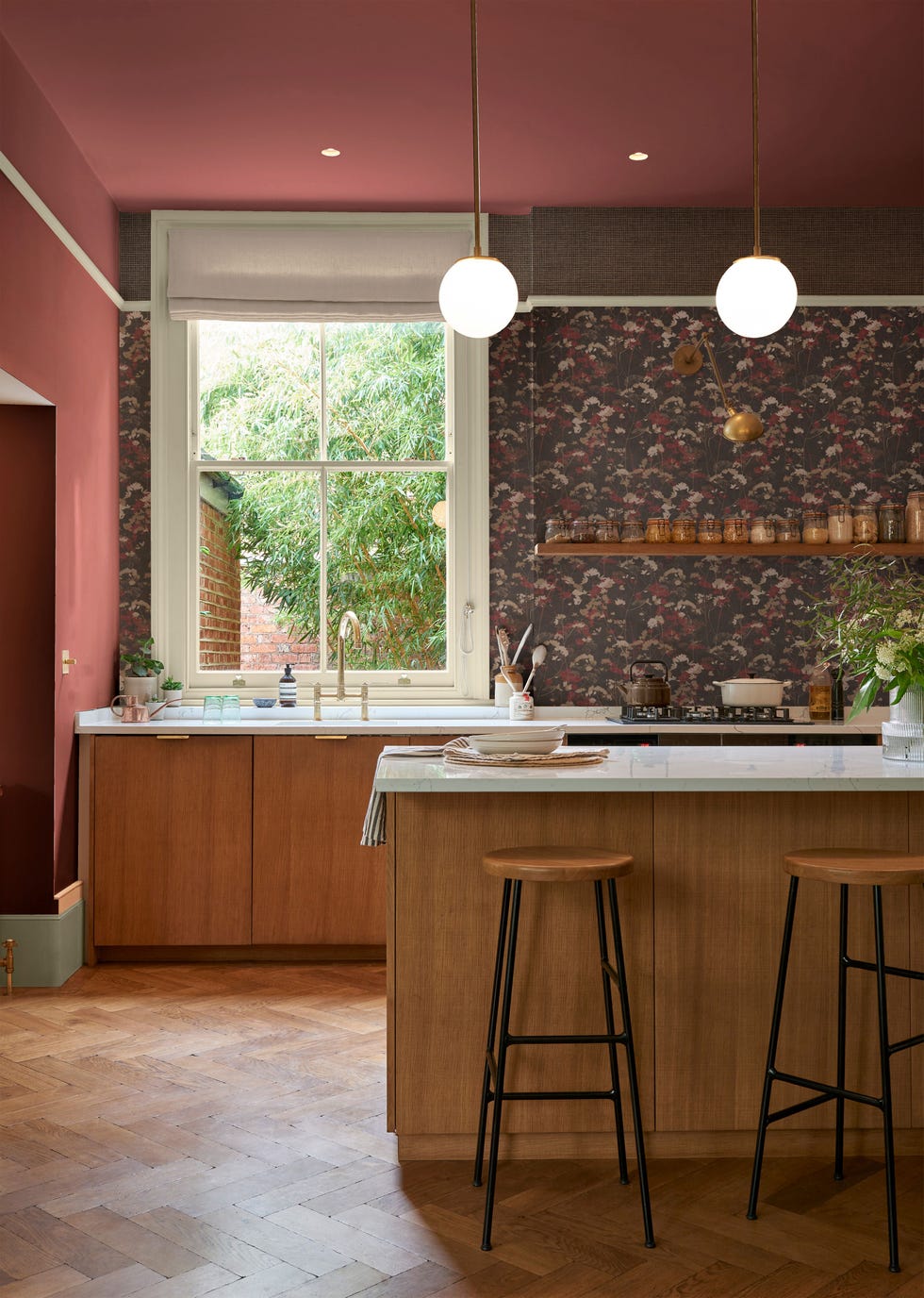 modern kitchen with red painted walls and ceiling and wallpapered accent wall