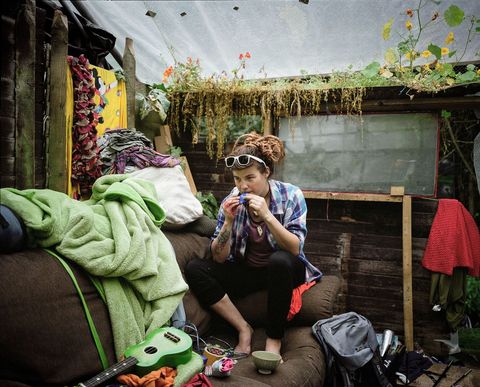 Een bewoonster zit in haar met planten gedecoreerde woonkamer