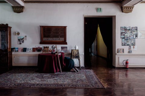 Nana 58 uit Sukhumi maakt schoon onder een tafel bij de receptie Ondanks dat er maar een handvol gasten per jaar verblijven poetsen de vrouwen elke kamer iedere dag