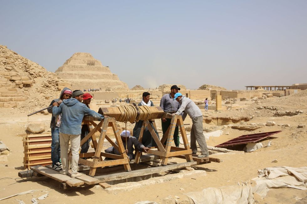 Arbeiders gebruiken een met de hand aangedreven lier om gereedschap en andere werktuigen naar de mummiewerkplaats en de graftombes te krijgen dertig en een halve meter onder de grond Het grafcomplex bevond zich op een van de beste plekken van Saqqara met zicht op de Trappiramide van Djoser een van de oudste en heiligste monumenten in Egypte