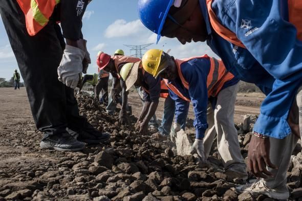 Arbeiders van de China Road and Bridge Corporation dat de dure spoorlijn bouwt verplaatsen stenen net buiten de oostelijke grenslijn van het nationale park van Nairobi Ongeveer 12 kilometer spoorlijn komt door het park te lopen