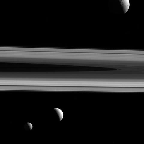 Drie van Saturnus manen  Tethys Enceladus en Mimas  zijn te zien op deze foto die door Cassini werd genomen