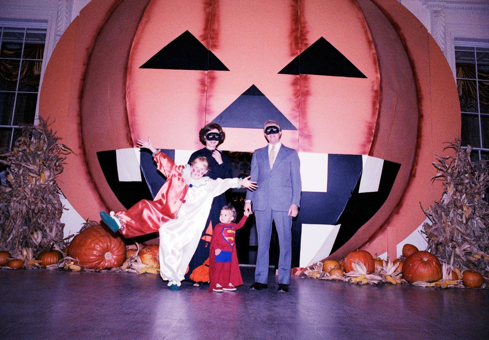 in this photograph, president jimmy carter, first lady rosalynn carter, their daughter amy, and their grandson jason pose for a group portrait in front of a large pumpkin on the north portico during a white house halloween party