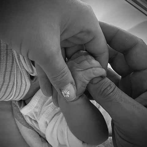 a black and white photo of katy perry and orlando bloom holding their daughter daisy's hand