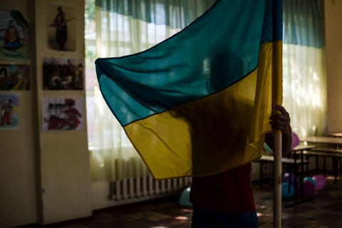Voordat hij zal deelnemen aan de dzhura een militairpatriottisch spel ontvouwt een leerling in Sjtsjastja Loehansk samen met klasgenoten de Oekraense vlag