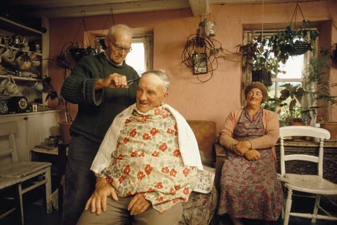 Een boer knipt het haar van een kennis in zijn keuken op het eiland Sark GrootBrittanni Deze foto verscheen in 1971 bij een artikel in National Geographic over de Kanaaleilanden