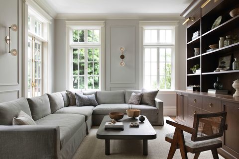 family room, wooden custom bookcase, crown moulding, sconces, gray sofa couch