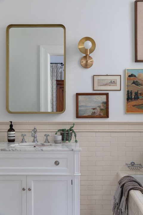 bathroom, subway tiles, white sink cabinets, marble countertop, faucet, wall art in bathroom