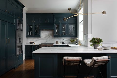 dark green kitchen, white countertops, gold chandelier