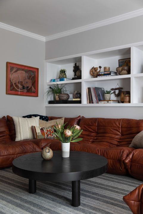 orange sofa, black wooden coffee table, stripped rug