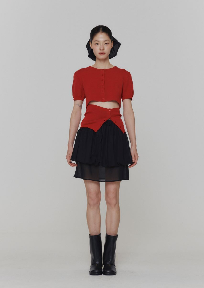 a woman in a red shirt and black skirt