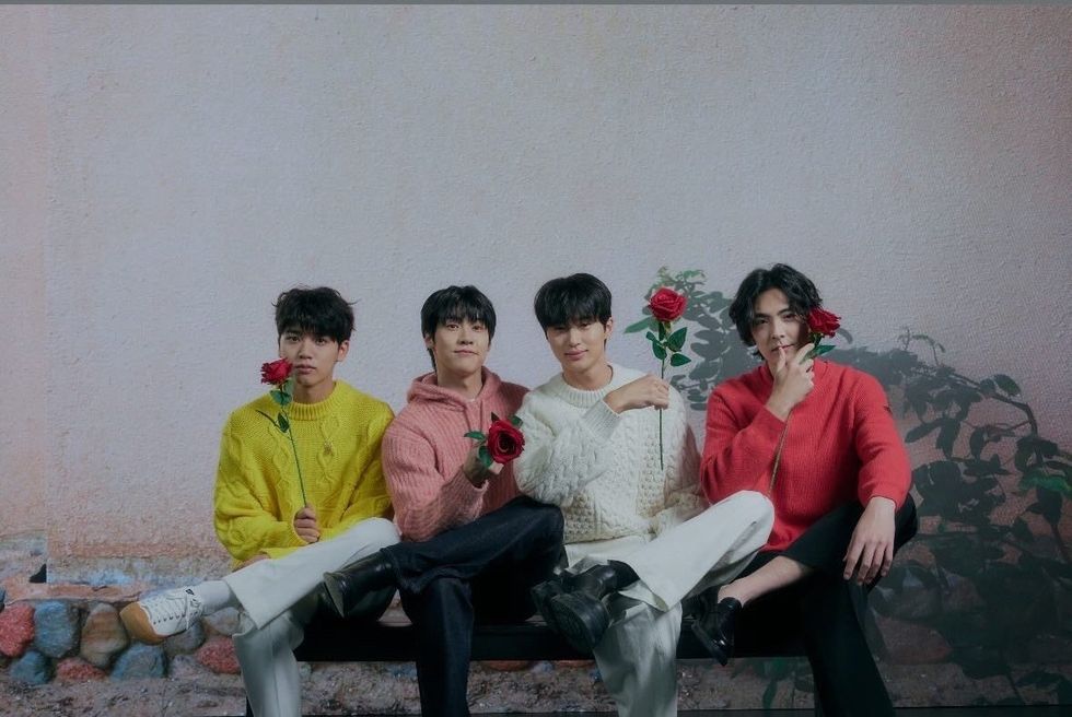 a group of people sitting on a couch holding flowers