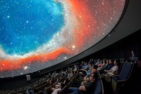 Bezoekers van het nieuwe Supernova Planetarium en Bezoekerscentrum bij Mnchen bekijken een opname van de Helixnevel een planetaire nevel op zon 655 lichtjaar afstand in het sterrenbeeld Waterman