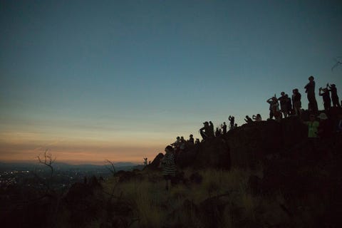 Op een heuvel die over Madras in Oregon uitkijkt ziet een groep mensen tijdens de totale zonsverduistering hoe even na tien uur s ochtends de avond valt