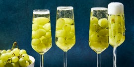 glasses of champagne filled with 12 green grapes