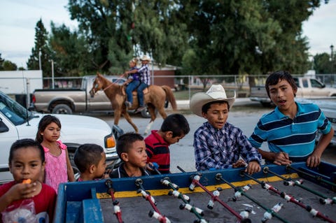 Kinderen spelen in Los Ejidos een boerencoperatie van de gemeenschap die een verzamelpunt vormt tijdens de cabalgata Zowel plaatselijke bewoners als hun familieleden die nu in de Verenigde Staten wonen komen naar dit speciale evenement dat wordt gehouden op slechts een uur rijden van de grens met Texas
