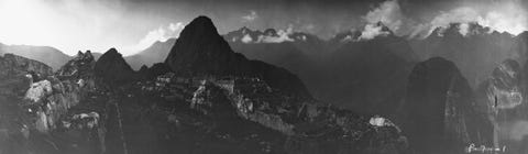 Deze panoramafoto genomen vanaf een hoger gelegen punt toont het complex van Machu Picchu in zijn geheel