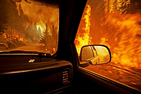 SEELEY LAKE MONTANA VS  Een brandweervoorman die vanuit zijn truck de schade opneemt nadat een ziedende bosbrand over een weg is geslagen staat een gevaarlijke route te wachten