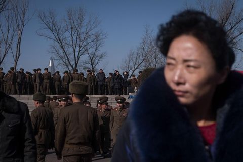 Tijdens de herdenkingsfestiviteiten staat een vrouw in burger voor een zee van soldaten Met 12 miljoen militairen in actieve dienst beschikt NoordKorea over een van de grootste legers ter wereld