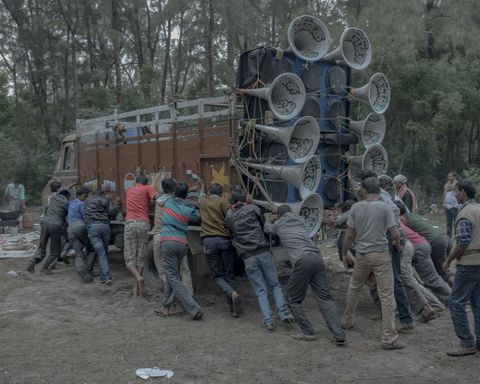 Een grote truck gevuld met een uitgebreid sound system staat vastgelopen in het zachte zand vlakbij de kust in West Bengal Een groep mannen zet een reddingsoperatie op om de truck te bevrijden