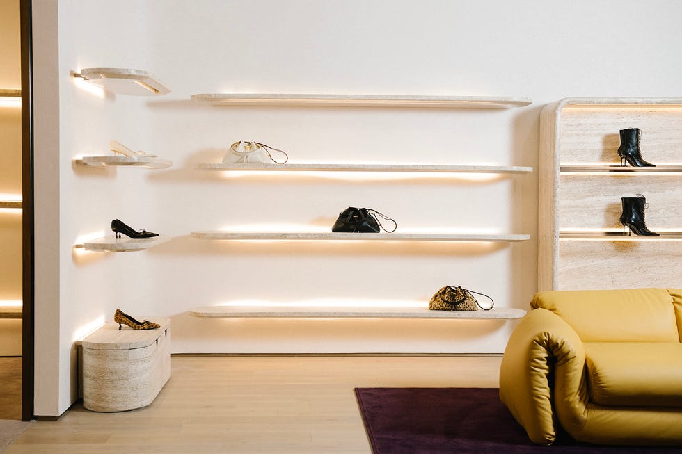 display of fashionable shoes and handbags on wall shelves with modern decor