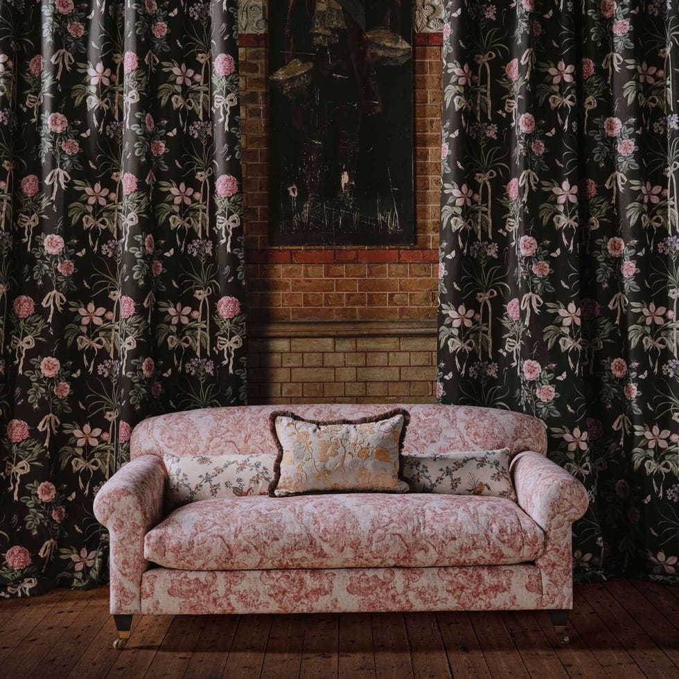 Victorian-style sofa and floral curtains in a room.