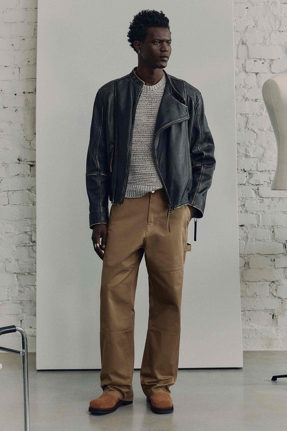 stylish outfit consisting of a leather jacket knit sweater and cargo pants