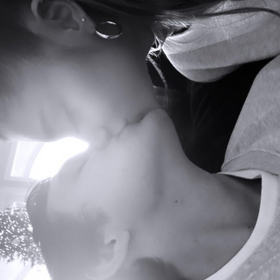 a sideways black and white photo closeup selfie of ariana grande and dalton gomez kissing