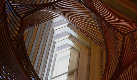 De lijnen van een fraaie sculptuur vormen samen met de verdiepingen van het Hyatt Regency San Franciscoeen spel van contouren en licht De sculptuur met de titel Sphere werd gemaakt door kunstenaar Charles O Perry en bestaat uit 1400 metalen buizen die zon 12 meter hoog reiken